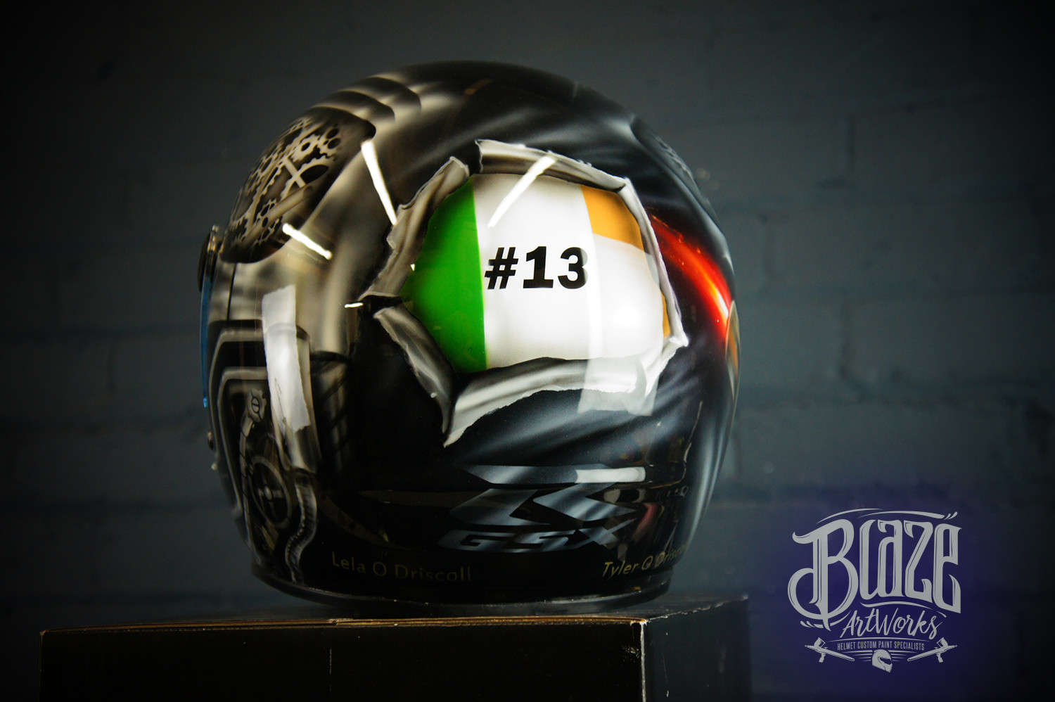 Black motorcycle helmet with airbrushed Irish tricolour flag design incorporating #13 number and skull elements in green white orange